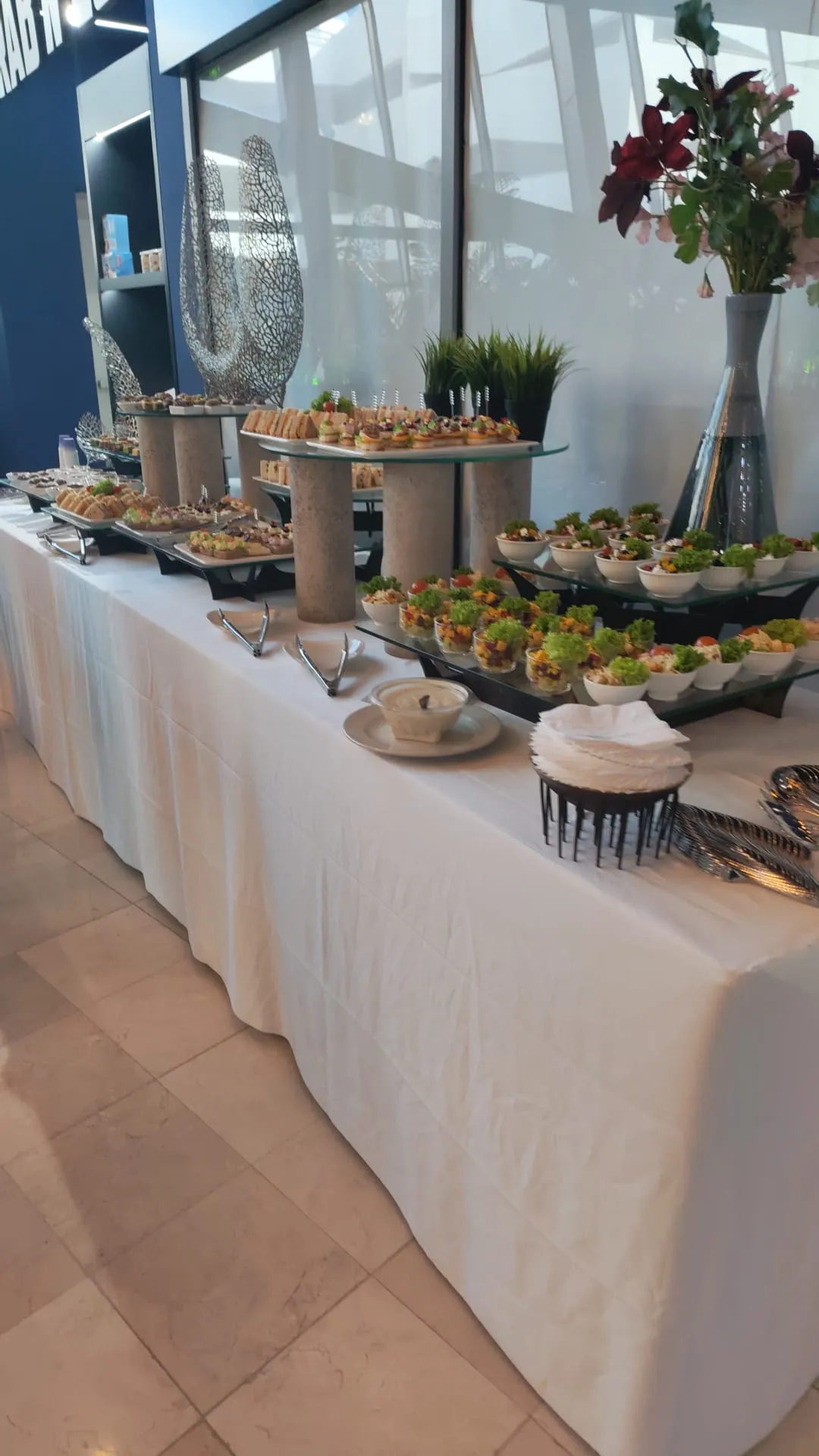 Catering buffet setup with salads, appetizers and serving plates