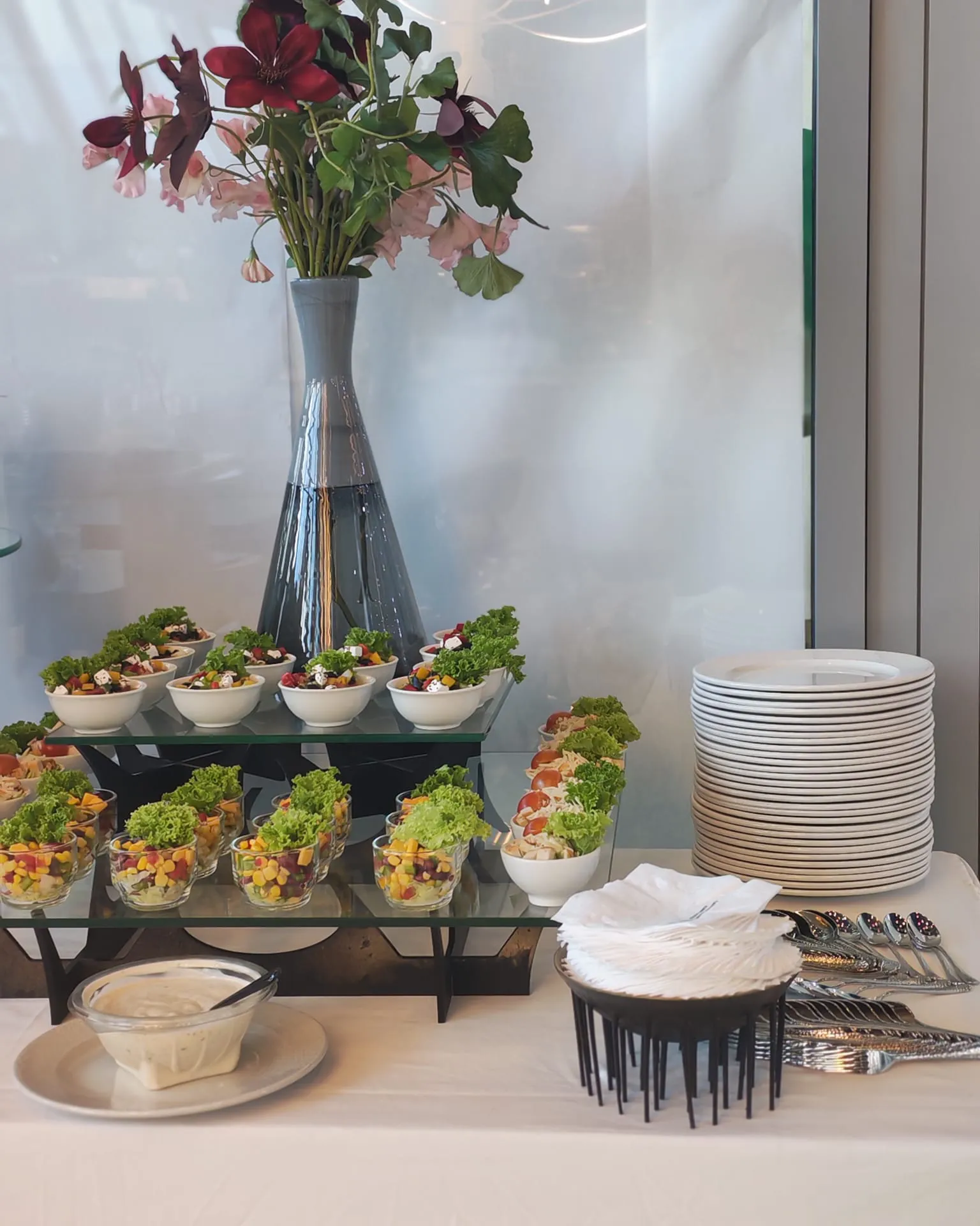 Close-up catering buffet with salads, plates and serving utensils