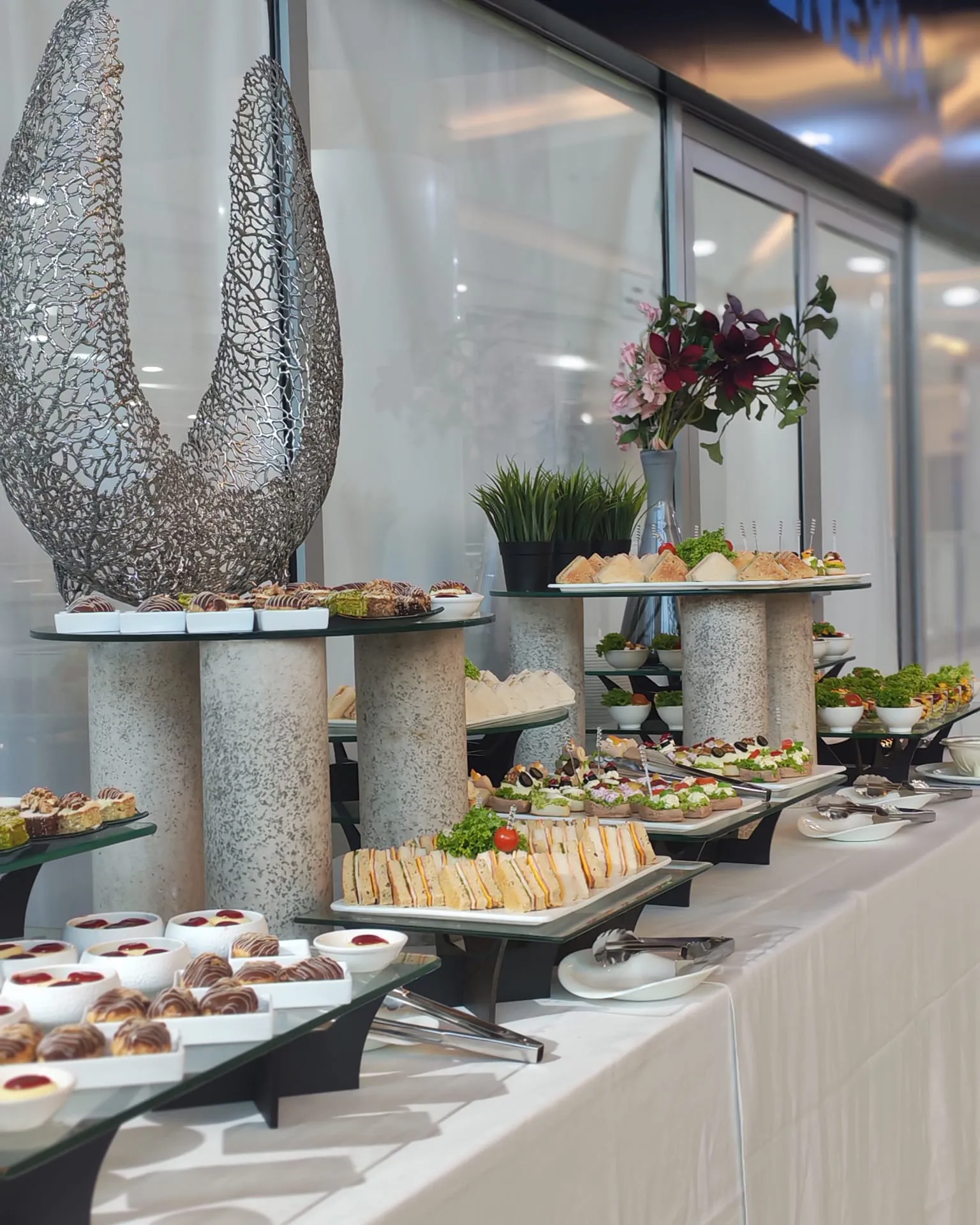 Event catering table with sandwiches, desserts and appetizers