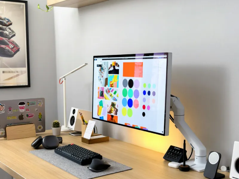 A design workstation with color swatches displayed on a monitor.