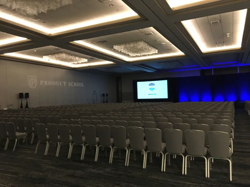 Rows of chairs facing a presentation screen in a conference room.